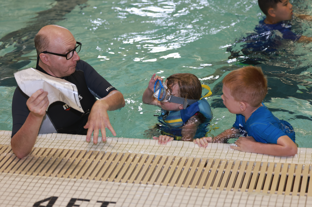 An instructor teaching swimming lessons. 